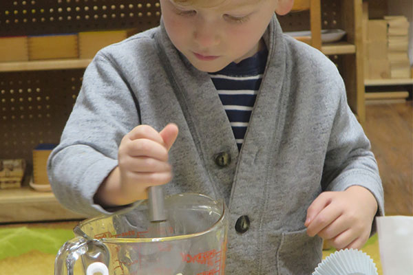child mixing in measuring cup
