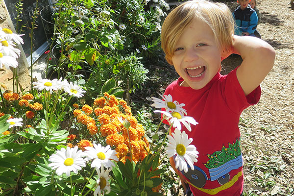 child outside next to flowers